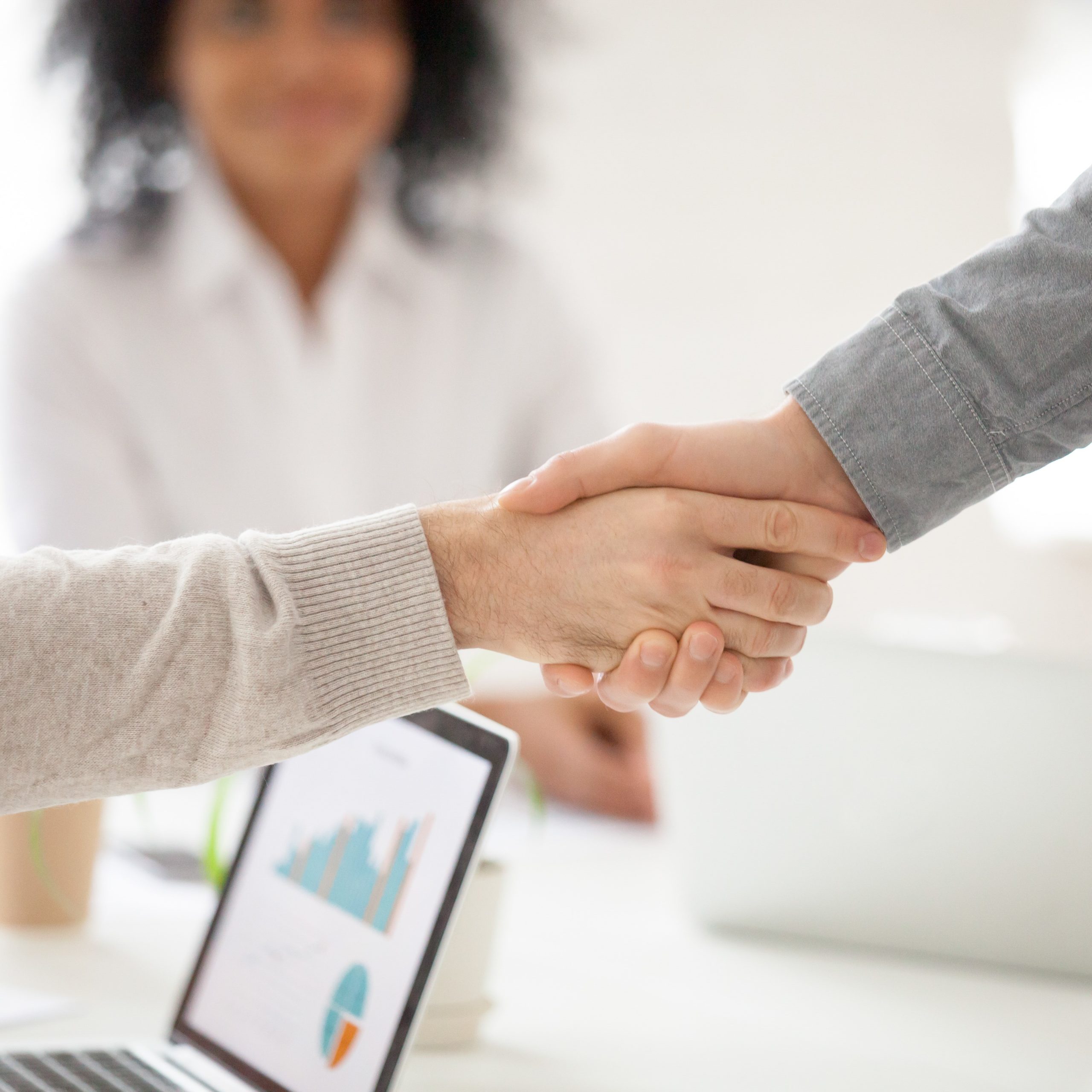 Two business partners handshake at group meeting making online project investment, male hands shake as concept of successful collaboration result or starting partnership after effective negotiations